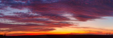 Panoramic view of colorful sunset sky with clouds. At dusk from a low angle of view.