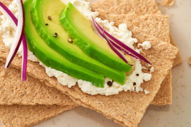 Avokado ve krem peynirli çıtır ekmek. Üst Manzara. Makro çekim.