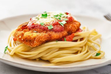 Parmesanlı tavuk ve spagettiyi tabağa koy. Düşük açı. Odak dizme ile makro çekim.