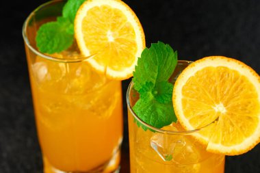 Buz küpleri ve nane yapraklarıyla portakal kokteyli. Yüksek açı görünümü.