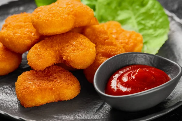 Kızarmış tavuk nugget ve domates soslu kase. Stüdyo çekimi.