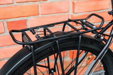 Modern bir MTB motorunun arkasına monte edilmiş metal bir bagaj. Yakın plan. Açık havada..