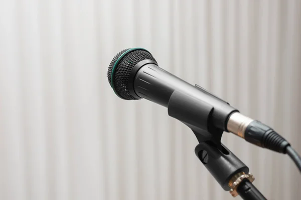 Close-up of a microphone for public speaking on a stand. Indoors.