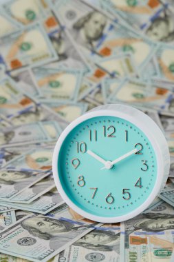 Yuvarlak analog saatler yüzlerce dolarlık banknotların üzerinde bulunur. Dikey çerçeve.