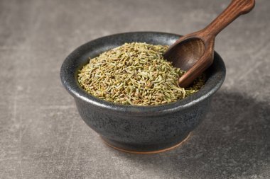 Tahta bir kepçeyle bir kasede doğranmış biberiye yakın plan. Ön görünüm düşük açıdan.