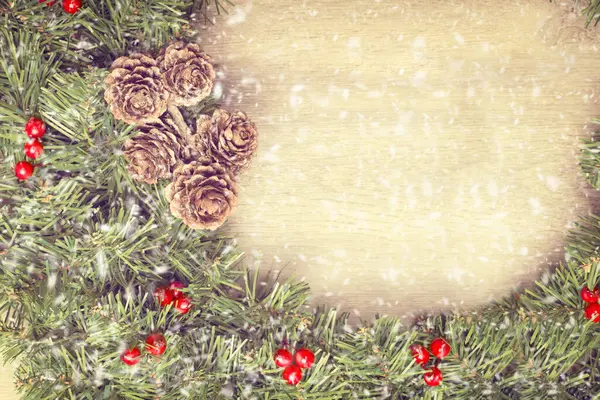 雪が降ると木製のドアからぶら下がってクリスマスの花輪 — ストック写真