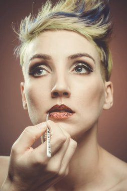 Tuhaf saçlı kız makyajını yaptırıyor.