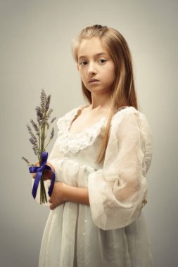 Mor kurdeleli bir demet lavanta tutan genç kız.