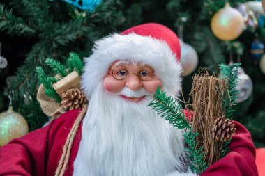 Noel Baba oyuncağı Noel ağacının önünde dünyanın dört bir yanındaki Xmas festivalinde renkli oyuncaklarla süslenmiş.