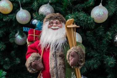 Noel Baba oyuncağı Noel ağacının önünde dünyanın dört bir yanındaki Xmas festivalinde renkli oyuncaklarla süslenmiş.