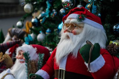 Noel Baba oyuncağı Noel ağacının önünde dünyanın dört bir yanındaki Xmas festivalinde renkli oyuncaklarla süslenmiş.