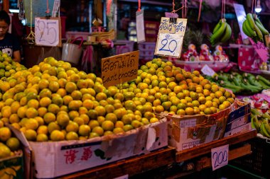 Bangkok 'taki Klong Toey pazarında yeşil-sarı derili olgun portakallar. Turuncu resim arkaplanı