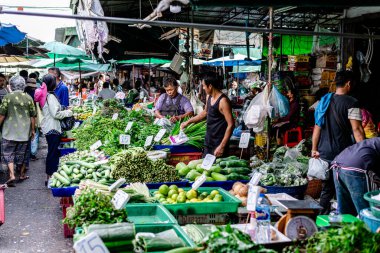 Bangkok, Tayland. - 15 Aralık 2023: Klong Toey 'deki taze sebze pazarı, bölgedeki müşterilere çeşitli sebzeler satan satıcılar..