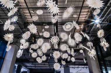 Alışveriş merkezinin tavanında asılı origami tarzıyla Noel dekorasyon arka plan dokusu.