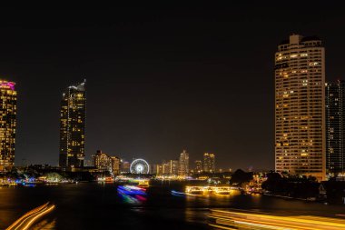Chao Praya nehri boyunca gece ışığı manzarası, Tayland 'ın Bangkok şehrindeki Asya' nın dönüm noktasında yeni yıl arifesini kutlamak için birkaç tekne geliyor..
