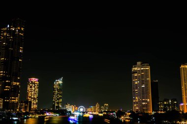 Chao Praya nehri boyunca gece ışığı manzarası, Tayland 'ın Bangkok şehrindeki Asya' nın dönüm noktasında yeni yıl arifesini kutlamak için birkaç tekne geliyor..