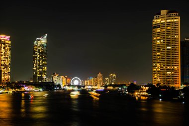 Chao Praya nehri boyunca gece ışığı manzarası, Tayland 'ın Bangkok şehrindeki Asya' nın dönüm noktasında yeni yıl arifesini kutlamak için birkaç tekne geliyor..