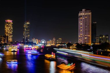 Chao Praya nehri boyunca gece ışığı manzarası, Tayland 'ın Bangkok şehrindeki Asya' nın dönüm noktasında yeni yıl arifesini kutlamak için birkaç tekne geliyor..