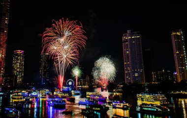 2024 yılını kutlamak için havai fişek gösterisi Chao Praya Nehri boyunca gece sahnesi ile Bangkok, Tayland 'daki Asitik kentinde.