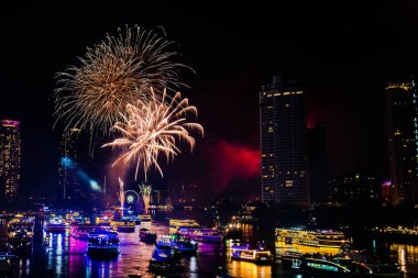2024 yılını kutlamak için havai fişek gösterisi Chao Praya Nehri boyunca gece sahnesi ile Bangkok, Tayland 'daki Asitik kentinde.