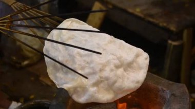 Beyaz Cornflakes geleneksel Tayland tatlısını kömür ocağında yapıyor..