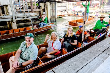 Damnoen Saduak 'ta yüzen pazar, yerel halkın tekne ve kanalda iyi şeyler satması açısından en iyi turistik ilgi odağı. Turistler de tekne gezisine çıkar. Ratchaburi, Tayland - 8 Ocak 2025.