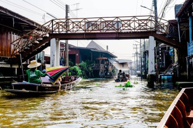 Damnoen Saduak 'ta yüzen pazar, yerel halkın tekne ve kanalda iyi şeyler satması açısından en iyi turistik ilgi odağı. Turistler de tekne gezisine çıkar. Ratchaburi, Tayland - 8 Ocak 2025.
