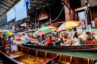 Damnoen Saduak 'ta yüzen pazar, yerel halkın tekne ve kanalda iyi şeyler satması açısından en iyi turistik ilgi odağı. Turistler de tekne gezisine çıkar. Ratchaburi, Tayland - 8 Ocak 2025.