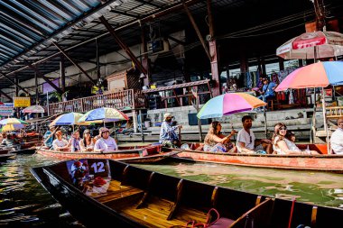 Damnoen Saduak 'ta yüzen pazar, yerel halkın tekne ve kanalda iyi şeyler satması açısından en iyi turistik ilgi odağı. Turistler de tekne gezisine çıkar. Ratchaburi, Tayland - 8 Ocak 2025.