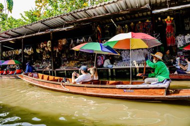 Damnoen Saduak 'ta yüzen pazar, yerel halkın tekne ve kanalda iyi şeyler satması açısından en iyi turistik ilgi odağı. Turistler de tekne gezisine çıkar. Ratchaburi, Tayland - 8 Ocak 2025.