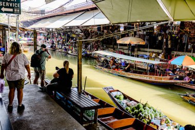Damnoen Saduak 'ta yüzen pazar, yerel halkın tekne ve kanalda iyi şeyler satması açısından en iyi turistik ilgi odağı. Turistler de tekne gezisine çıkar. Ratchaburi, Tayland - 8 Ocak 2025.
