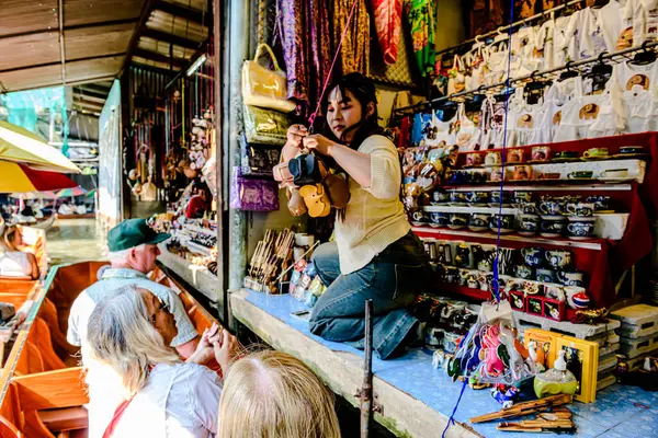 Damnoen Saduak 'ta yüzen pazar, yerel halkın tekne ve kanalda iyi şeyler satması açısından en iyi turistik ilgi odağı. Turistler de tekne gezisine çıkar. Ratchaburi, Tayland - 8 Ocak 2025.