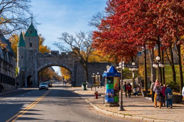 Quebec, Canada - October 23 2022 : Quebec City Old Town St. Louis Gate. Red maple leaf during autumn foliage.