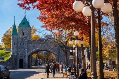 Quebec, Canada - October 23 2022 : Quebec City Old Town St. Louis Gate. Red maple leaf during autumn foliage.