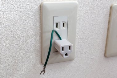 A travel adapter plug on the Japanese electric outlet in room.