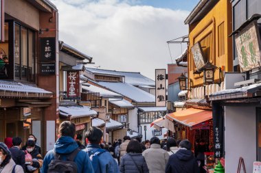 Kyoto, Japan - January 24 2023 : Japanese traditional buildings at Kiyomizu-zaka slope with snow in winter. Crowded with tourists at Kiyomizuzaka.