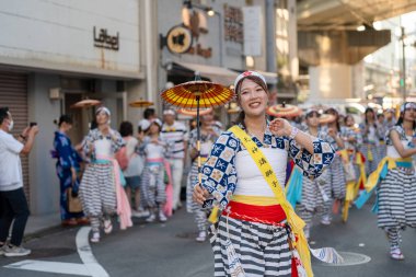 Osaka, Japonya - 25 Temmuz 2023: Tenjin Matsuri Festivali. Şemsiye dansçıları sokaklarda yürüyor..