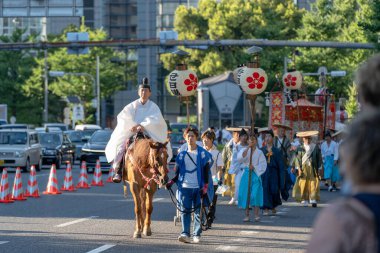Osaka, Japonya - 25 Temmuz 2023: Tenjin Matsuri Festivali. Geleneksel kıyafetler giyen insanlar sokaklarda yürüyor..