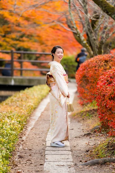 Japanese Female Kimono Portrait photography. Maple leaves turning red in the autumn season in Kyoto Philosopher\'s Path ( Tetsugaku No Michi ). Fall foliage in Japan.
