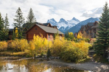 Sonbaharda Canmore kasabası. Alberta, Kanada. Spring Creek 'teki Canmore Opera Binası. Arka planda Üç Kız Kardeş üçlüsü.