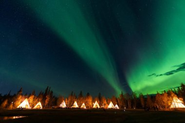 Kuzeybatı Bölgesi, Yellowknife 'daki Aurora Köyü' nde Tipi ya da Tepee ışıklarının üzerinde dans eden inanılmaz kuzey ışıkları.