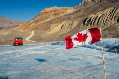 Columbia Icefield 'ın Athabasca buzulunda Kanada bayrağı ve buz kaşifi aracı Jasper Ulusal Parkı, Alberta, Kanada.