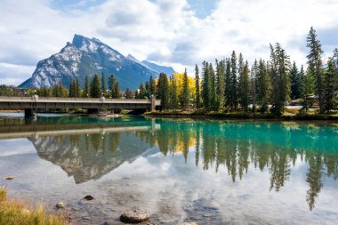 Banff Central Park Trail manzarası sonbaharda Bow River 'a yansıdı. Arka planda Rundle Dağı Sıradağları var. Banff Ulusal Parkı, Alberta, Kanada.