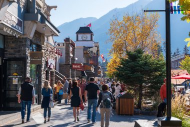 Banff, Alberta, Kanada - 06 Ekim 2022: Güneşli bir sonbahar gününde Banff Bulvarı 'nda alışveriş yapan kalabalık.