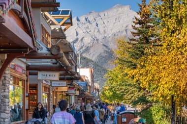 Banff, Alberta, Kanada - 06 Ekim 2022: Güneşli bir sonbahar gününde Banff Bulvarı 'nda alışveriş yapan kalabalık.