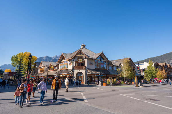 Banff, Alberta, Canada - October 06 2022 : Tourists walking on Banff Avenue in a autumn sunny day.