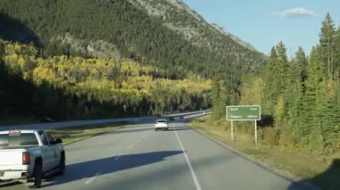 Alberta, Kanada - 28 Eylül 2023: Güneşli bir sonbahar gününde 1. Otoyolda (Trans-Canada Karayolu) araba kullanmak. Banff Ulusal Parkı, Kanada Kayalıkları.
