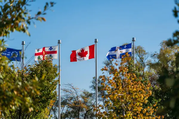 stock image Quebec, Canada and Montreal flags waving in the Jean-Drapeau Park, Montreal, Quebec, Canada.