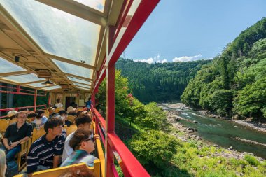 Kyoto Eyaleti, Japonya - 11 Ağustos 2024: Sagano Manzara Demiryolu üzerinde turistler demiryolu boyunca doğal manzaranın tadını çıkarıyorlar.