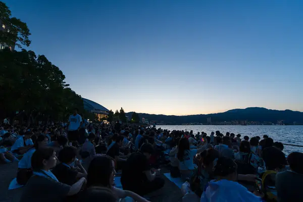 stock image Shiga Prefecture, Japan - August 8 2024 : Lake Biwa Great Fireworks Festival. People are sitting on the lakeshore waiting for the fireworks to start.